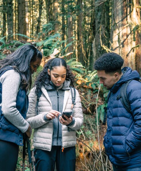 Groupe de jeunes en forêt avec un smartphone
